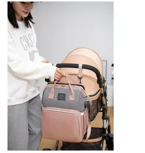 Sac à langer rose et gris avec crochets pour poussette accroché à la poignée du landau