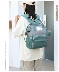 Detail of the high-capacity mommy backpack in teal and gray with a side coin purse