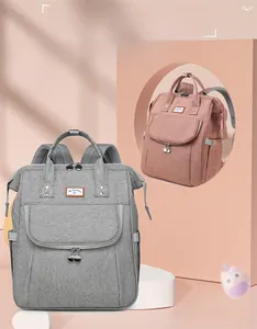 Large capacity diaper backpack in grey and pink with reinforced handles and multiple pockets