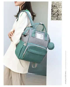 Detail of grey mommy backpack with ID info label and round coin purse attachment
