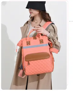 Close-up of coral mommy bag with reflective safety strip and heart quilted texture