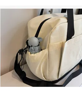 Gros plan sur la poche latérale du sac de sport beige avec rangement pour parapluie