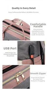 Detail of pink and grey canvas diaper bag showing reinforced handle, USB port, and metal zippers