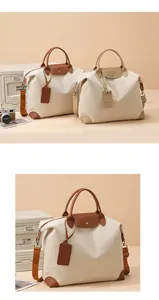 Detail of canvas travel bag featuring leather trim, durable handles and adjustable shoulder strap