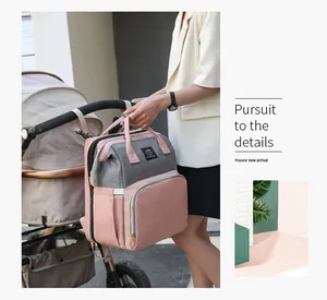 Zaino fasciatoio rosa e grigio appeso al passeggino con dettagli portaoggetti