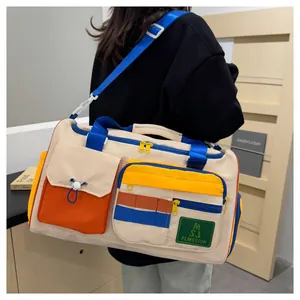 Detail of color-block travel bag with multiple pockets and blue adjustable strap