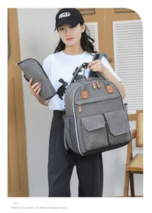 Dettaglio dello zaino grigio multi-tasca con accenti in pelle marrone e mini pochette