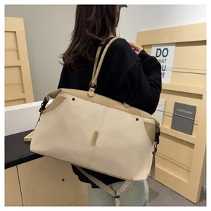 Close-up of beige canvas travel bag with leather straps and adjustable shoulder belt