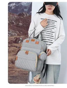 Detail of grey diaper backpack with diamond-stitched pocket and sunshine emblem