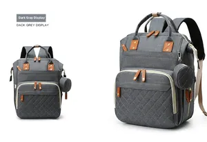 Detail view of dark grey diaper backpack with quilted front pocket and hanging coin purse