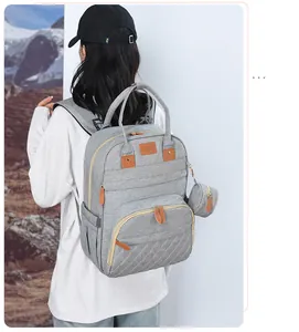 Detail view of light grey large capacity diaper backpack with sunshine leather tag and coin pouch