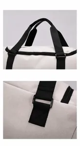 Detail of ergonomic padded carry handles and durable stitching on beige travel bag
