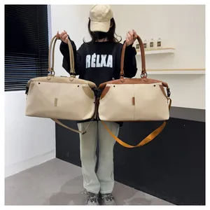 Large canvas travel duffel bag with leather trim and adjustable shoulder strap shown in use