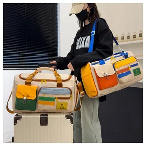 Close-up of a large canvas travel bag with colorful pockets and adjustable shoulder strap