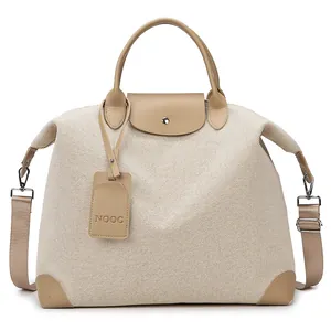 Large beige canvas travel tote bag with brown leather trim and detachable shoulder strap