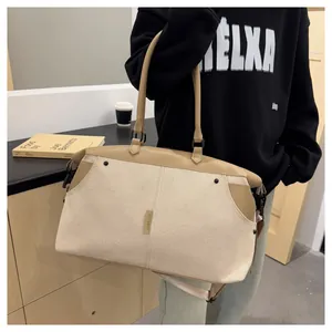 Detail of canvas travel bag with durable leather handles and branded textile patch