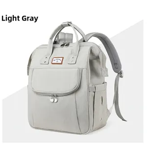 Front view of a light grey multi-functional diaper bag with durable fabric and brown logo