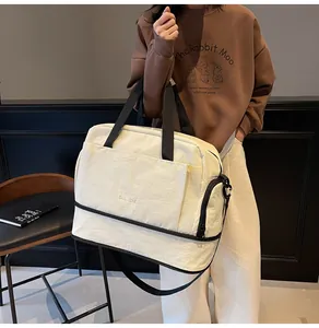 Détail du sac de sport crème avec compartiment à chaussures et bandoulière réglable
