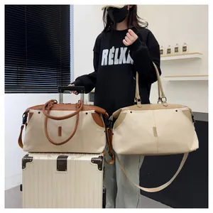 Detail of canvas duffel bags with leather handles and adjustable crossbody straps