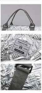 Detail of silver quilted travel bag with reinforced handles and vintage woven label logo