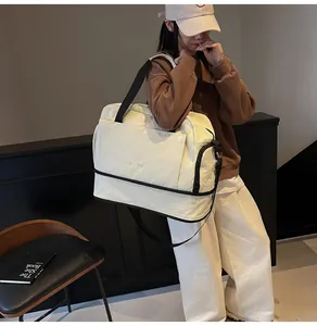 Gros plan du sac de sport beige avec compartiment à chaussures et large sangle noire