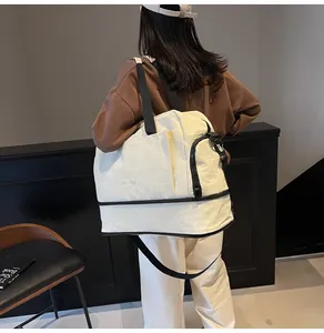 Détail d'un sac de fitness en toile blanche avec compartiment à chaussures séparé