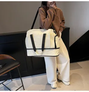Vue détaillée du sac de voyage crème avec compartiment à chaussures séparé en bas