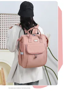 Pink diaper backpack with reinforced leather handles and large storage capacity
