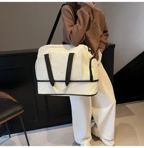 Détail du sac de voyage crème avec compartiment à chaussures séparé et bandoulière réglable
