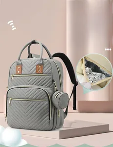 Detail of grey diaper backpack with quilted design and insulated baby bottle pockets