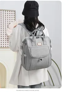 Detail of grey diaper backpack showing high-quality fabric texture and leather handles