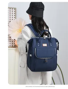 Detail view of navy blue diaper backpack with leather logo and durable canvas texture