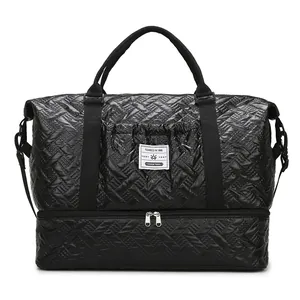 Large black travel bag with quilted texture, bottom shoe compartment and dual handles