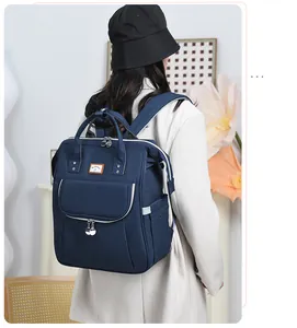 Detail of dark blue multi-compartment diaper backpack with white zipper accents
