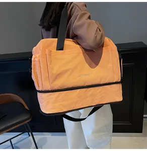 Vue détaillée du sac de fitness orange avec compartiment à chaussures et texture en nylon
