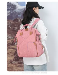 Dettaglio dello zaino fasciatoio rosa in tessuto con eleganti finiture in pelle marrone