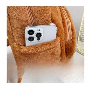 Close-up of the plush capybara backpack side pocket showing capacity with a smartphone