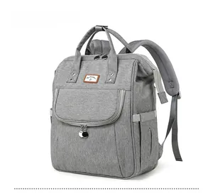 Detailed side view of grey multifunctional diaper backpack with reinforced top handle and pockets