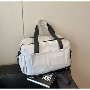 Gros plan d'un sac de sport imperméable gris clair avec poche latérale à cordon