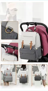 Multifunctional diaper backpack detail showing handheld, shoulder, and suitcase strap options