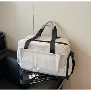 Gros plan du sac de fitness gris clair avec tissu imperméable et compartiment à chaussures