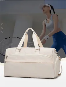 Detail view of the beige sports travel bag showing the specialized separate shoe compartment