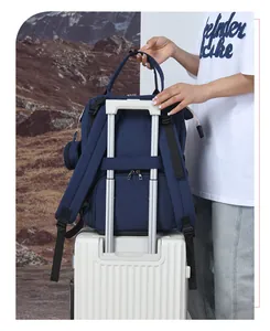 Dettaglio dello zaino mamma blu navy con fascia fissata sul manico di una valigia