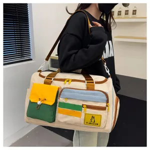 Detail of color-block travel bag with multiple pockets and adjustable shoulder strap