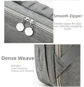 Detail view of smooth double metal zippers and reinforced stitching on the gray diaper bag