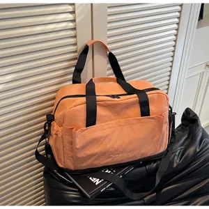 Détail macro du sac de voyage en nylon orange avec tissu durable et compartiment à chaussures séparé