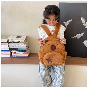 Detail of soft brown capybara plush backpack with star embroidery and side pocket