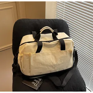 Vue détaillée du grand sac de sport crème avec des bretelles de transport robustes