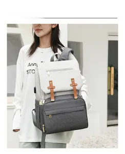 Detailed view of large grey mommy bag with USB port and stylish leather buckle straps