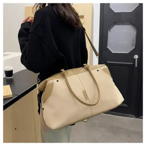 Detail of a large canvas travel bag showing the bicolor beige fabric and leather straps